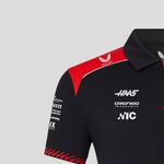 Black and red polo shirt with various sponsor logos on a gray background