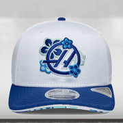 White cap with blue floral design and logo on a light gray background