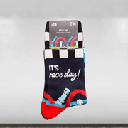 A pair of socks with a race day theme, featuring a car and the text 'IT'S RACE DAY!' on a blue and red design, packaged with a black and white striped card.